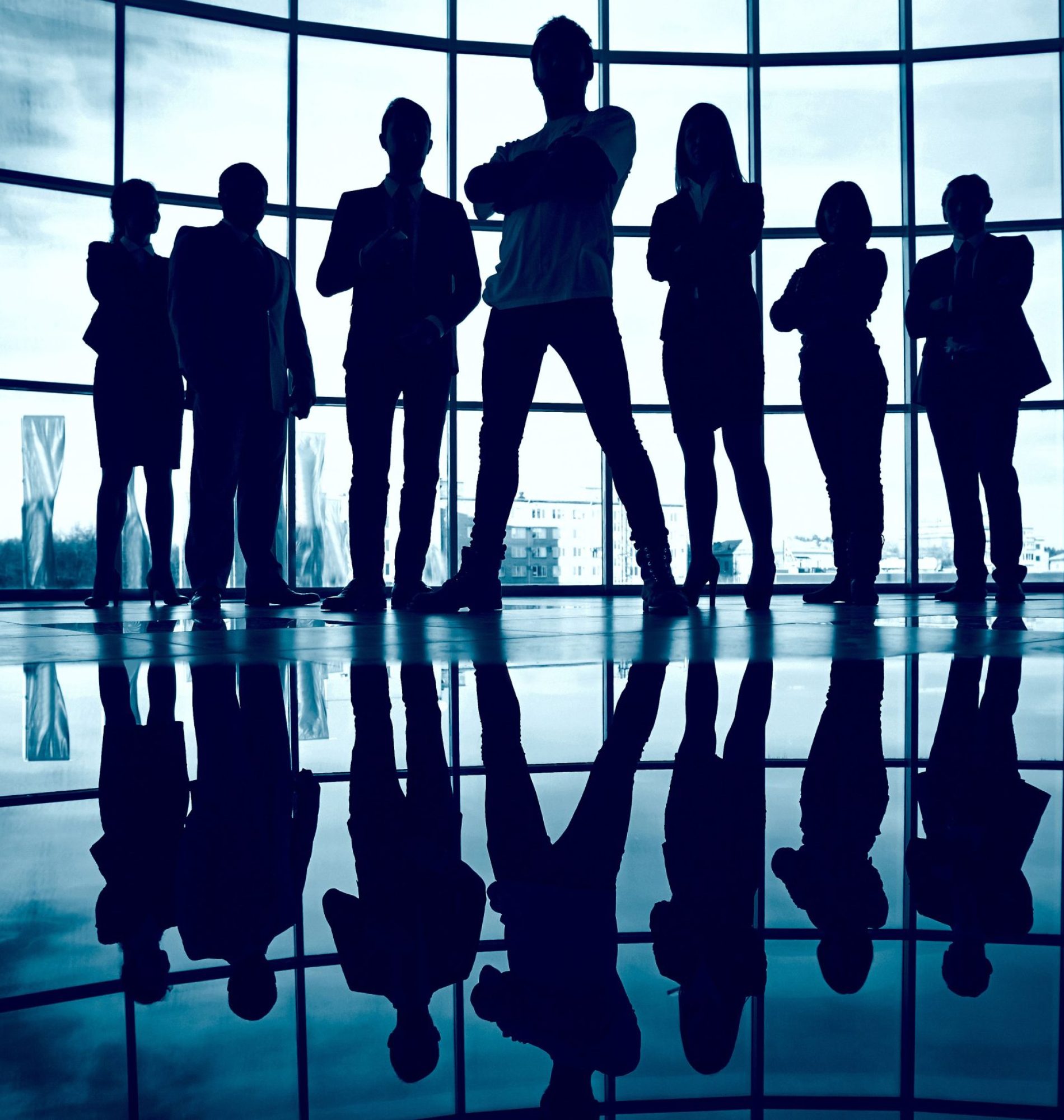 Business team standing against window with leader in front